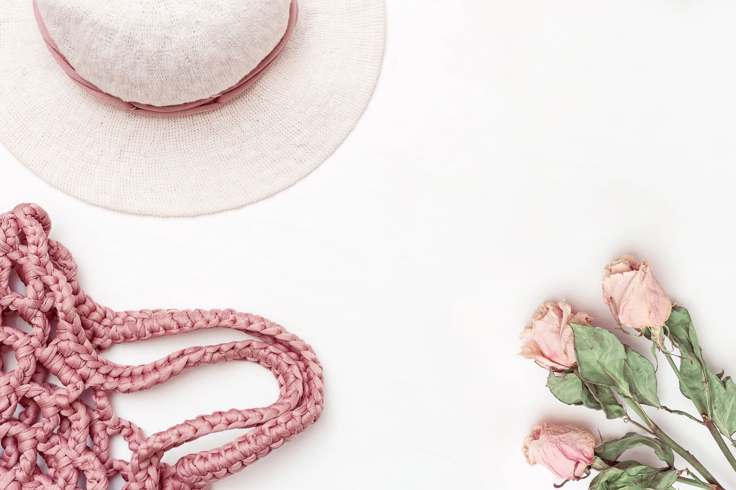 Flat lay of women's accessories and apparel on a light background