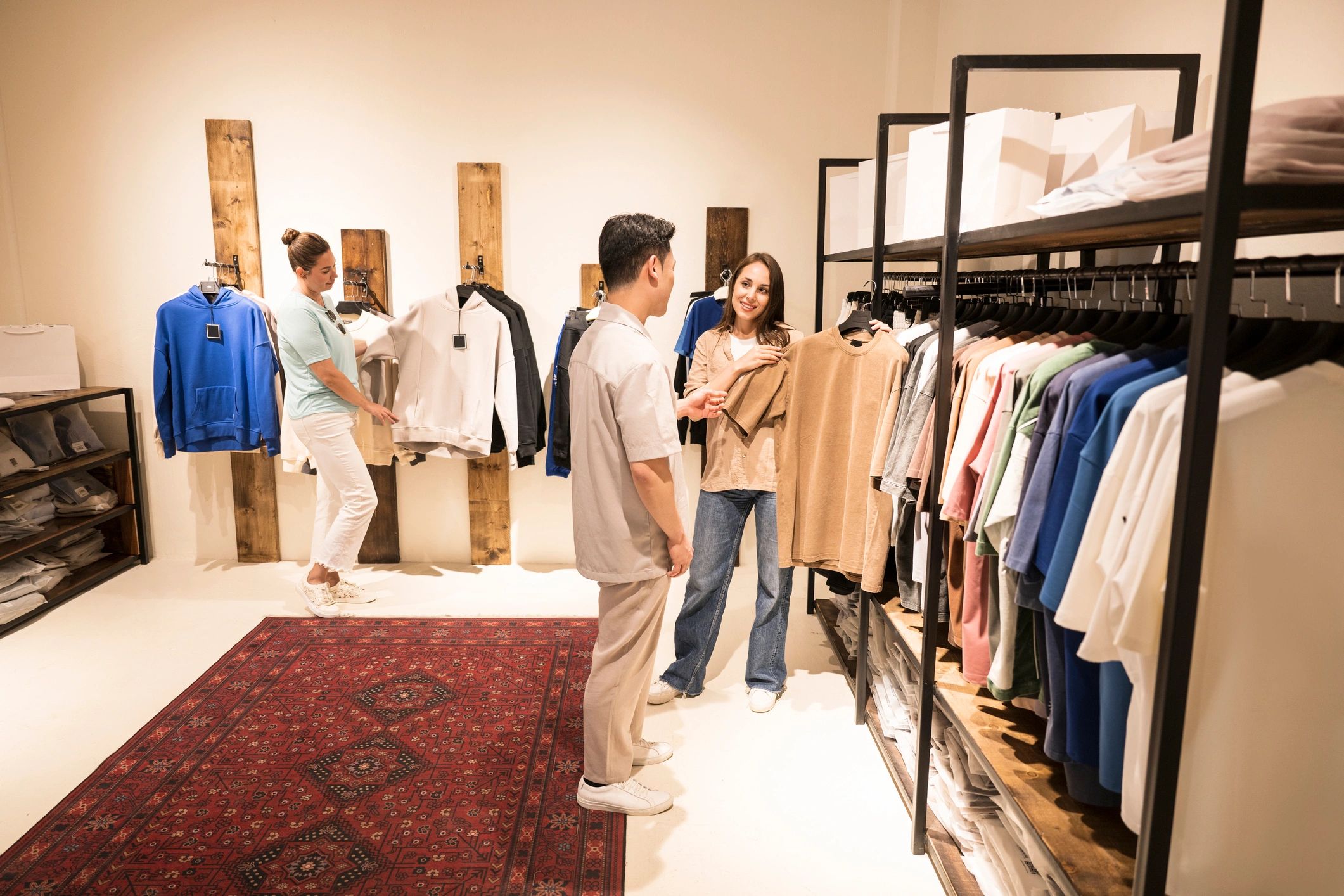 Customers browsing fashionable clothes inside a modern clothing store